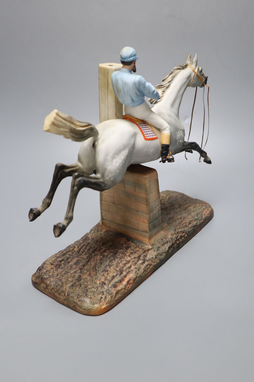 A cast coloured bisque porcelain horse and jockey group, height 26cm